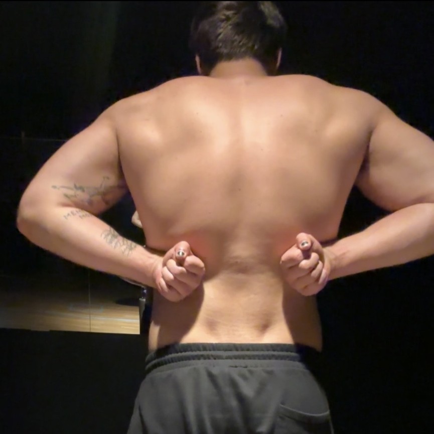 Axa flexing his back in the gym